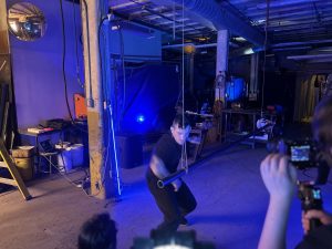 A man dances in a blue industrial room.